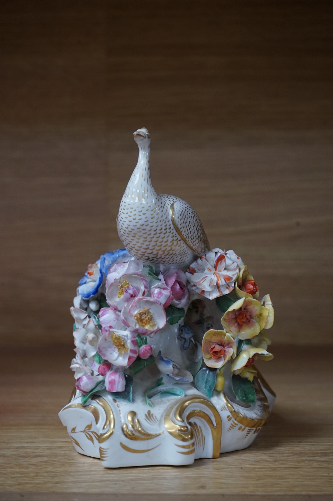 An ornate Bloor Derby peacock with floral encrusted decoration, 16cm high
